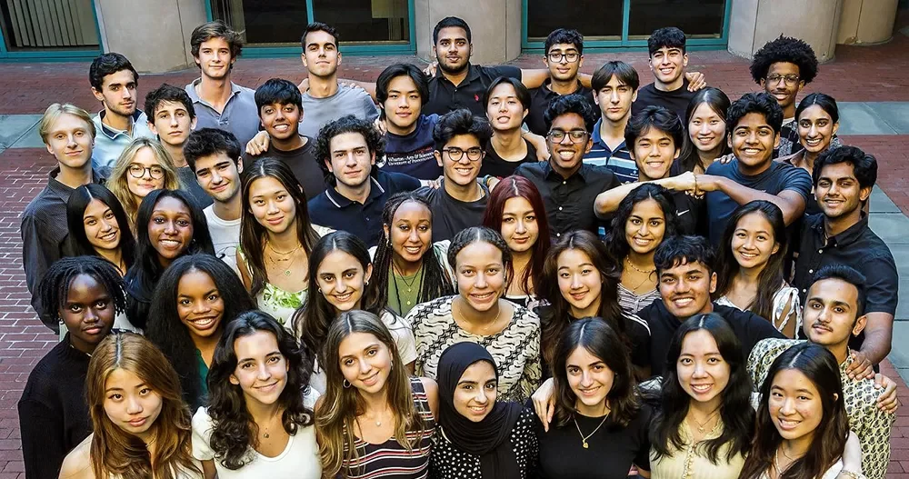 A large group of Huntsman Program students gathered for a group photo in a courtyard.