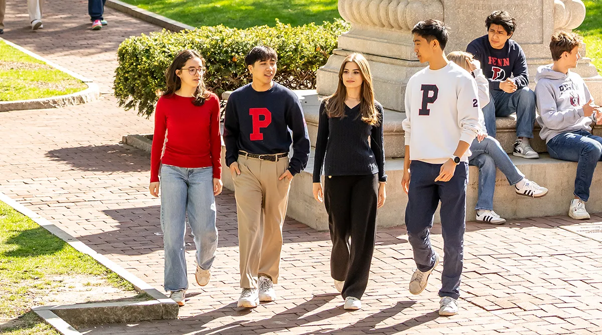 University of Pennsylvania undergraduates enjoy campus life, walking and chatting outside on Locust Walk.