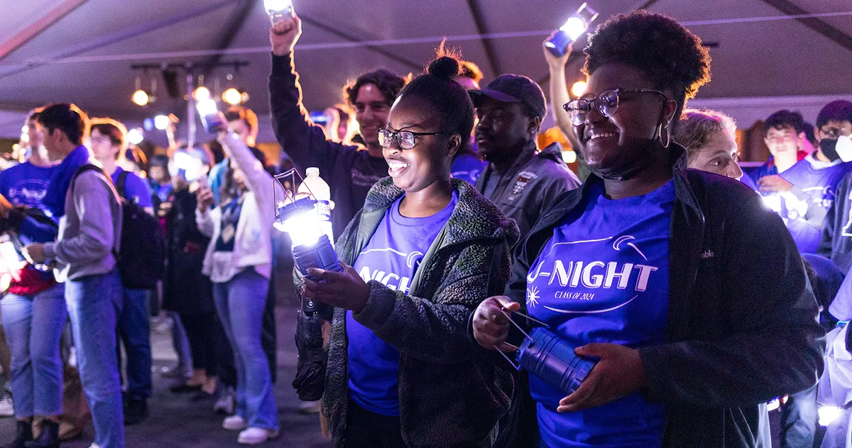 Penn students hold glowing lights and cheer during U-Night, a spirited class tradition supported by The Penn Fund.